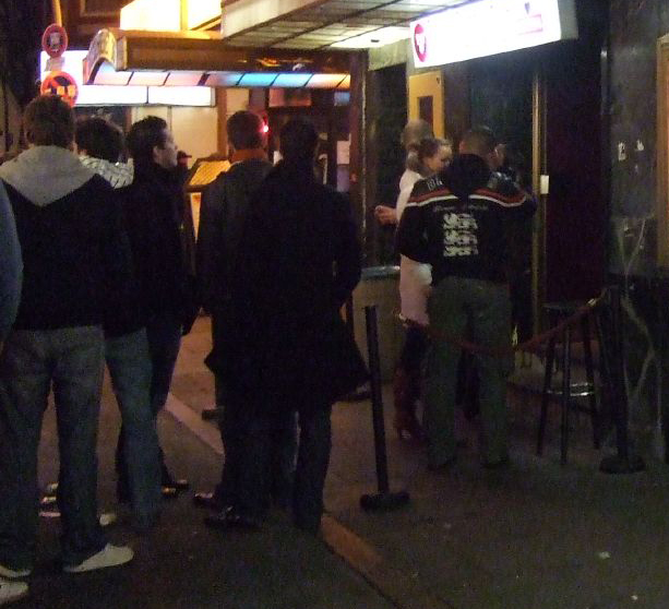 File:Bouncer checking IDs at a nightclub.jpg
