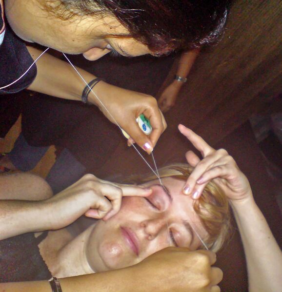File:Woman getting her eyebrows threaded.jpg